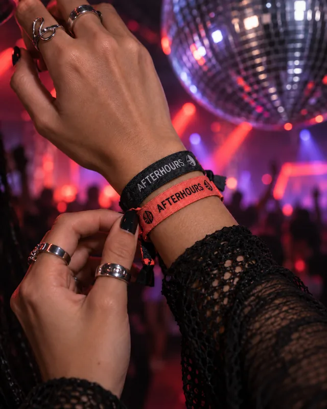 AFTERHOURS coral and charcoal woven wristbands, silver jewellery and reflected festival light